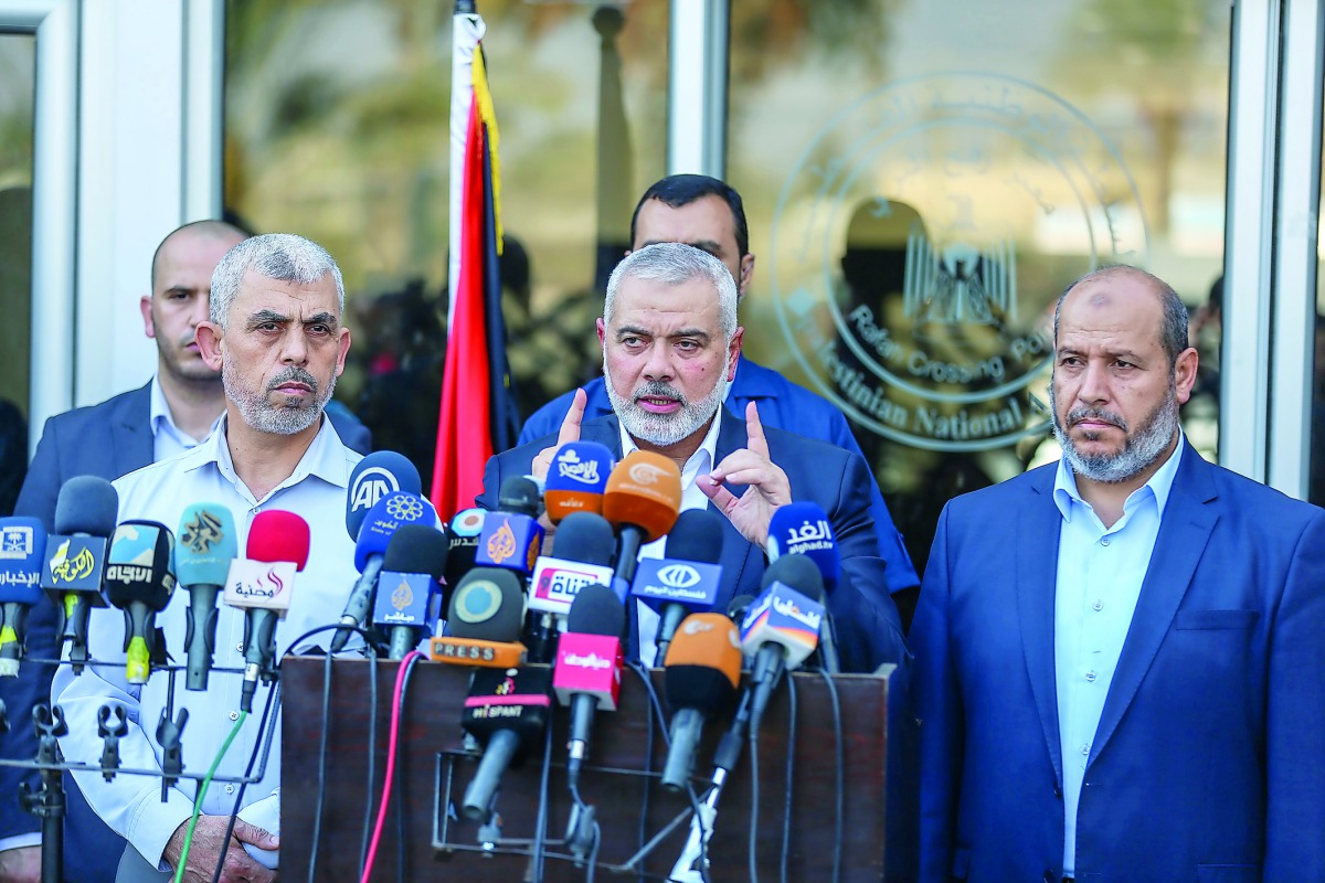 Ismail Haniyah (centre), Head of the Political Bureau of Hamas, speaking to media at Rafah border crossing following his visit to Egypt, yesterday.