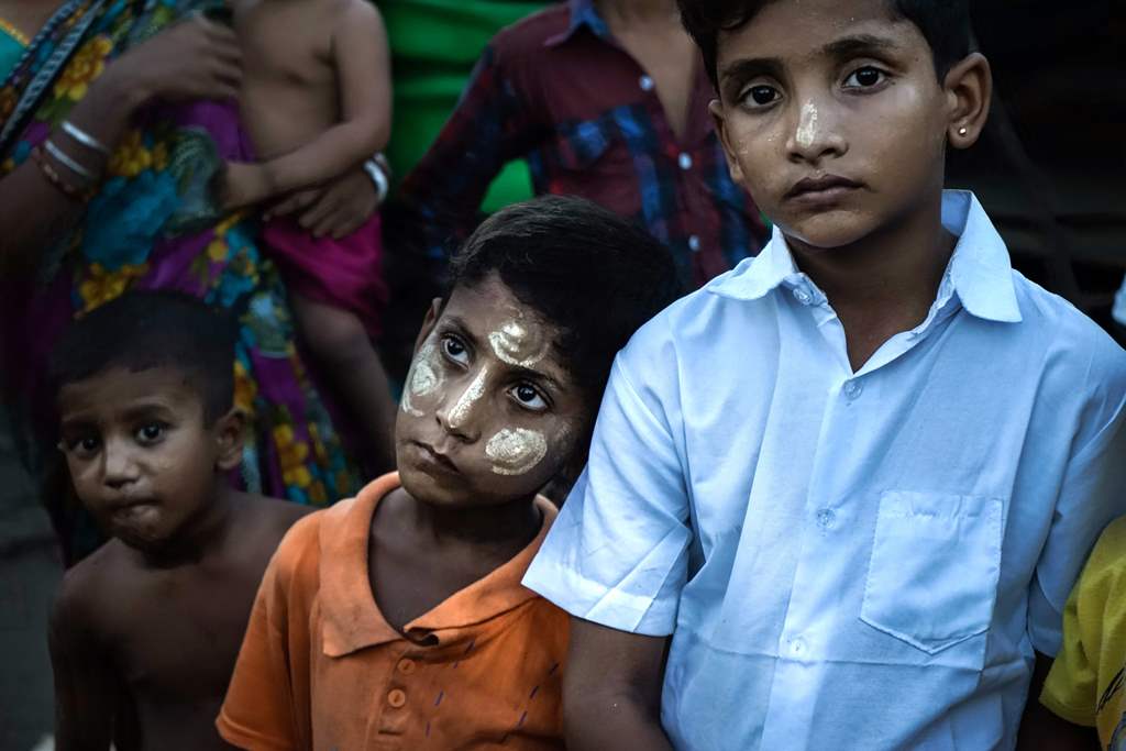 This photograph taken on September 21, 2017 shows Hindu boys wearing traditional cosmetics stand in the yard of a IDP camp for Hindu at the Sri Sri Moha Dev Bari Hindu Temple in Sittwe, in Myanmar's Rakhine state. AFP / Aidan JONES