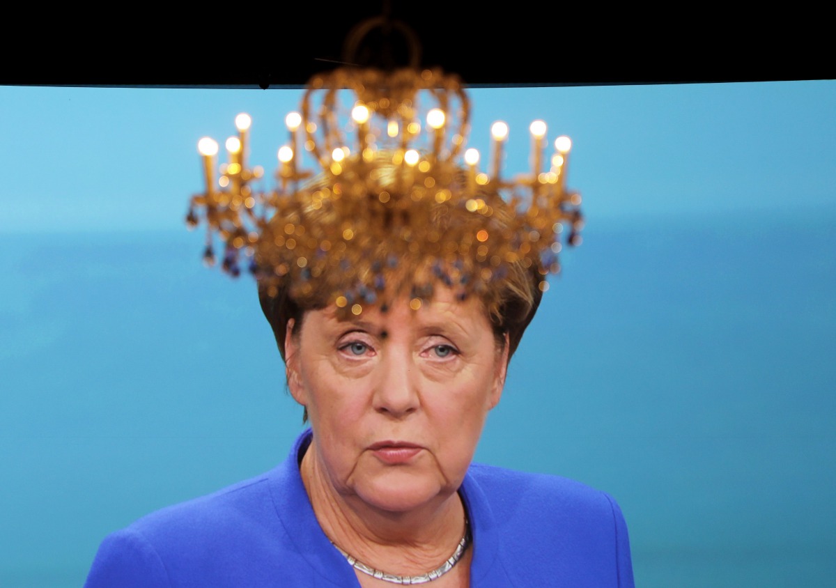 A chandelier hangs in front of a giant TV screen showing German Chancellor Angela Merkel on September 3, 2017 (AFP / dpa / Kay Nietfeld) 