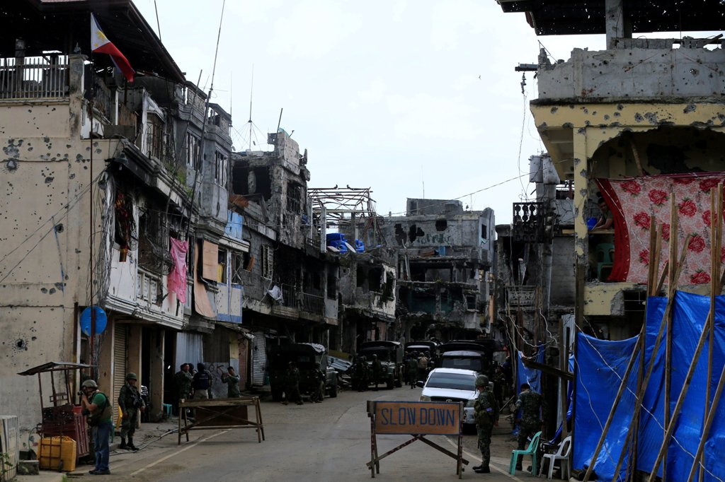 Government soldiers stand guard in front of damaged houses and building in Sultan Omar Dianalan boulevard at Mapandi district in Marawi city, southern Philippines September 13, 2017. Picture taken September 13, 2017. REUTERS/Romeo Ranoco
