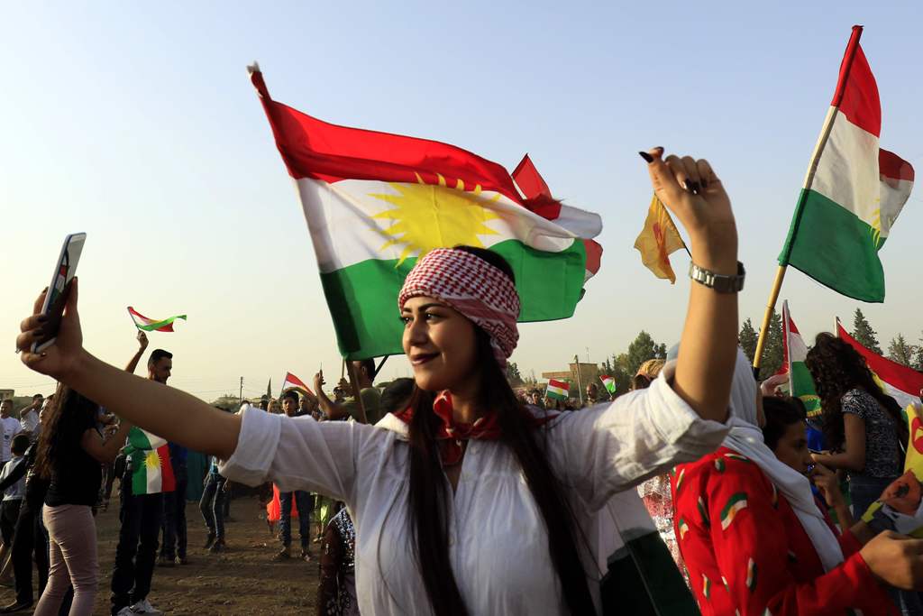 A Syrian Kurd takes a selfie, in the northeastern Syrian city of Qamishli on September 26, 2017, during a gathering in support of the independence referendum in Iraq's autonomous northern Kurdish region. / AFP / Delil souleiman