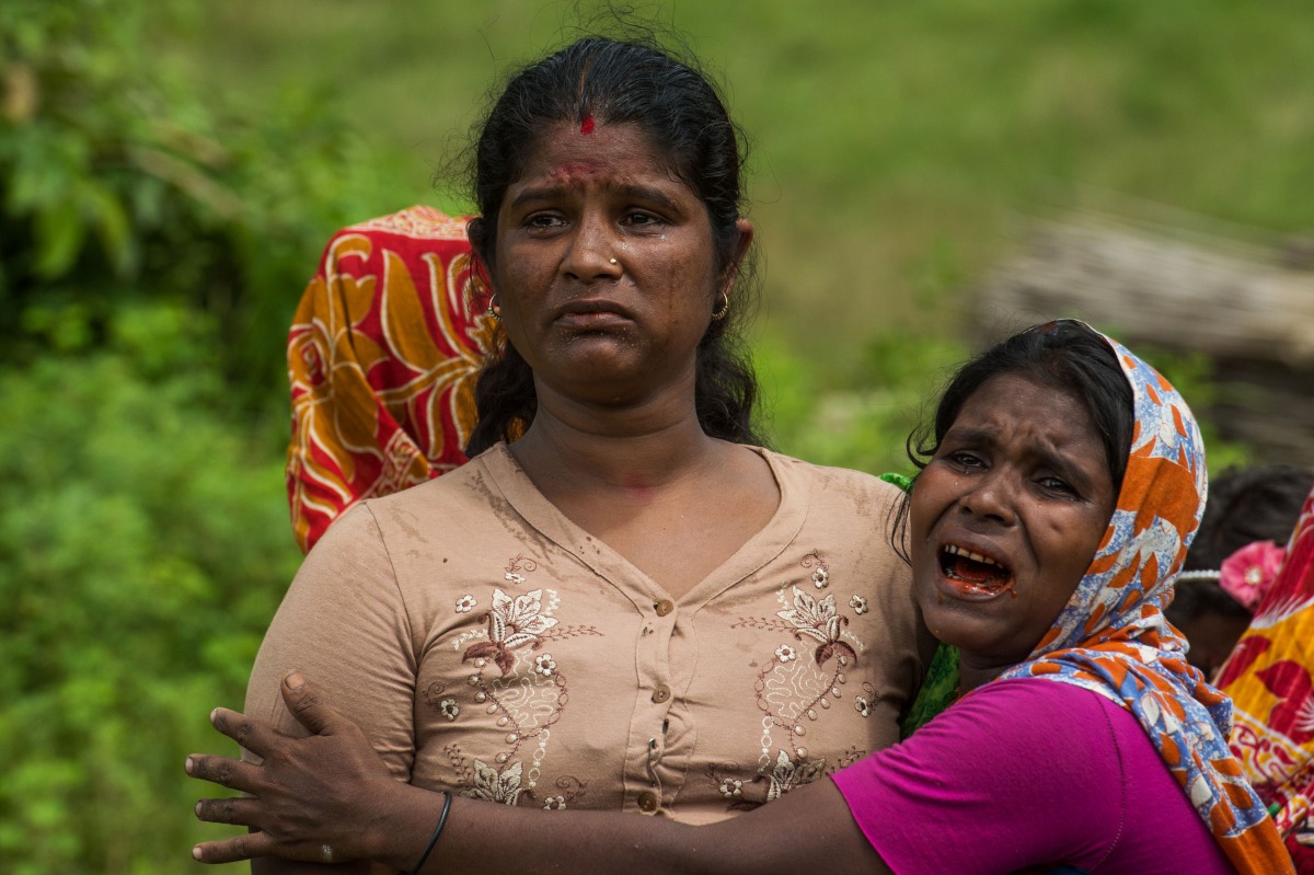 Hindu women cry near the dead bodies of their family members in YeBawKya village near Maungdaw, north of Myanmar's Rakhine state on September 27, 2017. AFP