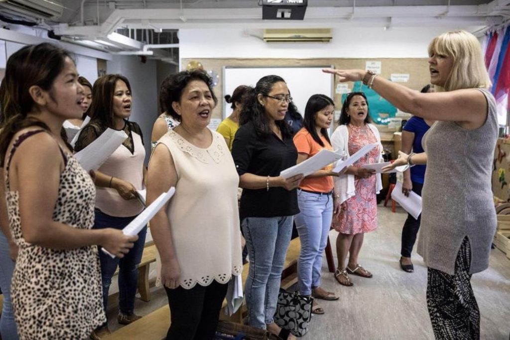 Unsung Heroes choir founder Jane Englemann leads her group of Filipina domestic workers during a practice session inside a kindergarten school's classroom in Hong Kong on Sept 3, 2017. PHOTO: AFP.