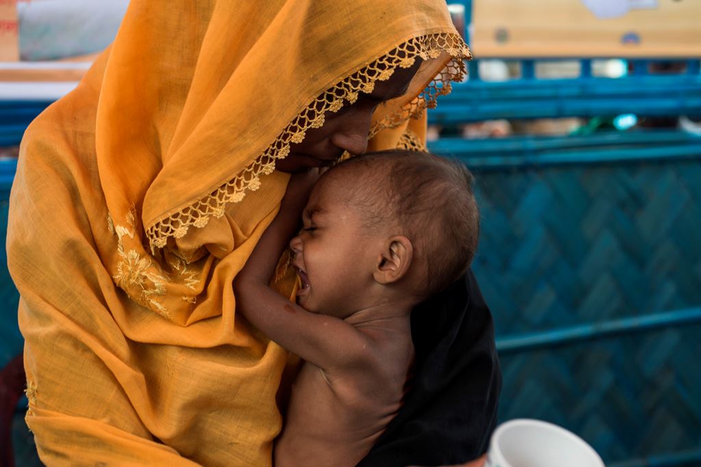 In this picture taken on October 1, 2017, a Rohingya Muslim refugee holds her child as she waits to see a doctor at a medical centre at Balukhali refugee camp near the town of Gumdhum in Cox's Bazar. AFP / FRED DUFOUR 