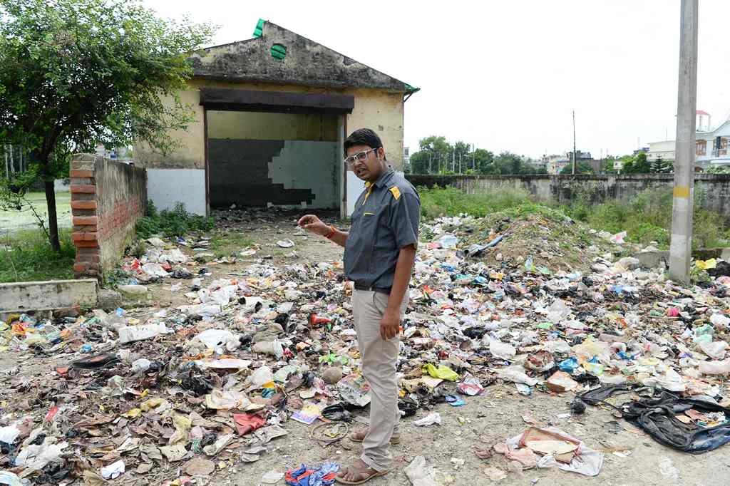 In this photograph taken on August 20, 2017, Durgesh Mishra stands near a dumpsite as he speaks during an interview with an AFP reporter in Gonda district, in the Indian state of Uttar Pradesh. AFP / SAJJAD HUSSAIN 