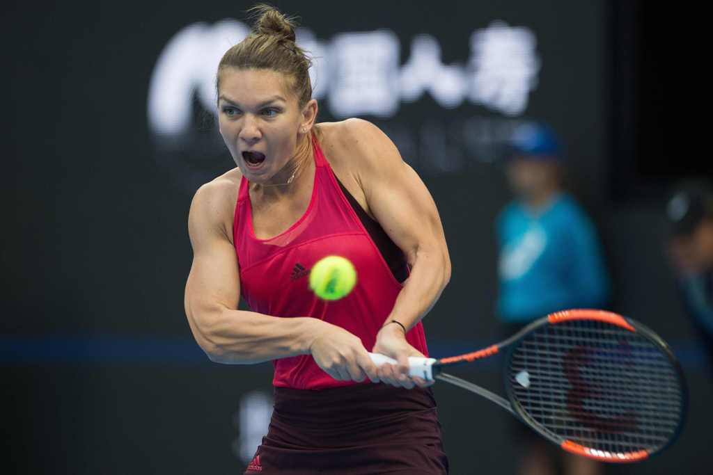 Simona Halep of Romania hits a return during her women's singles match against Maria Sharapova of Russia at the China Open tennis tournament in Beijing on October 4, 2017. / AFP / NICOLAS ASFOURI