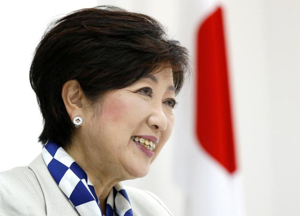 Tokyo Governor Yuriko Koike, head of Japan's Party of Hope, smiles next to a Japanese national flag during an interview with Reuters in Tokyo, Japan October 6, 2017. REUTERS/Issei Kato.