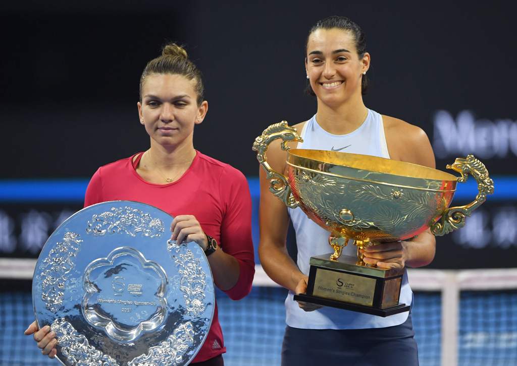 Caroline Garcia of France (R) holds the trophy after winning the women's singles final against Simona Halep of Romania (L) at the China Open tennis tournament in Beijing on October 8, 2017. / AFP / GREG BAKER
