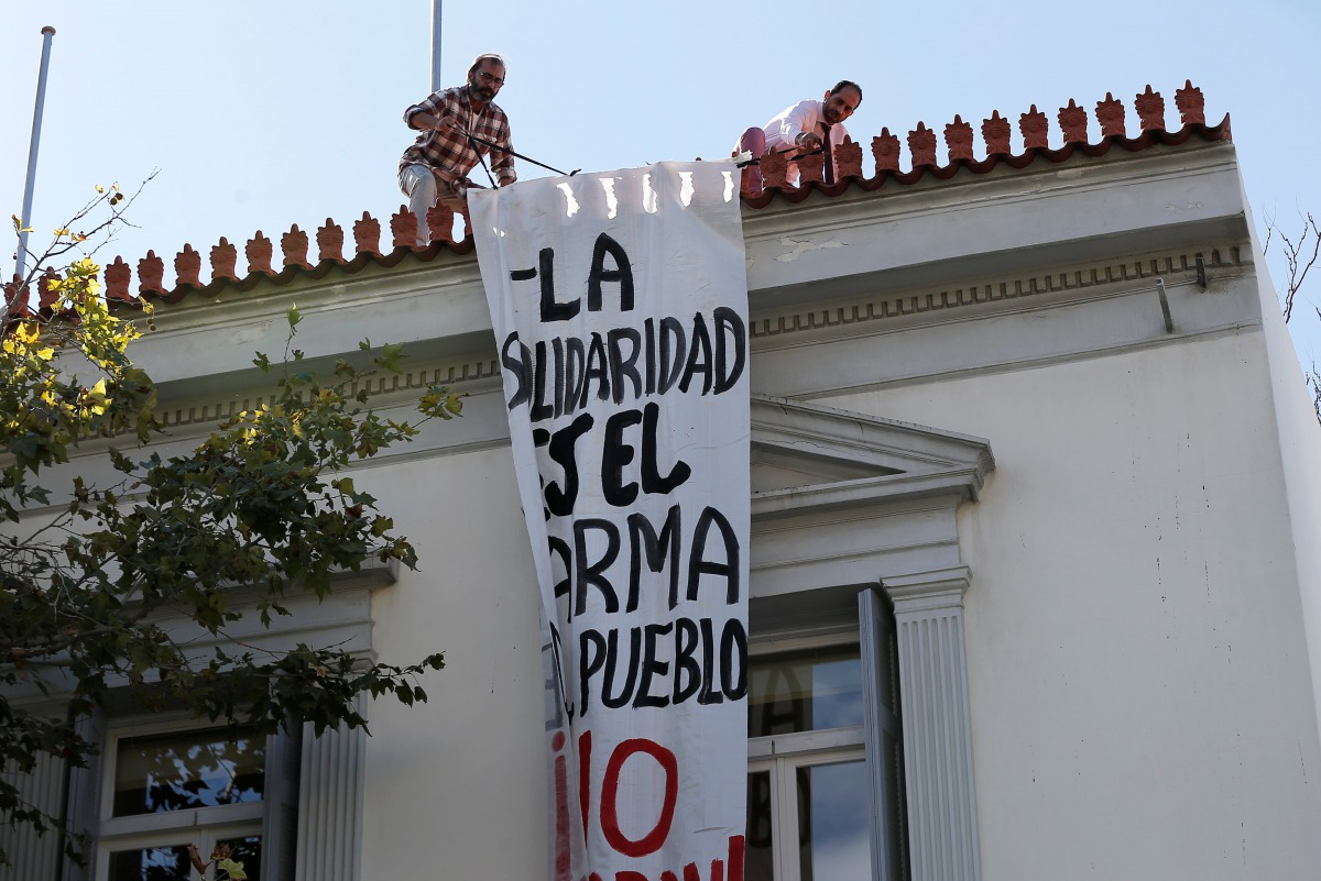 Employees of the Spanish embassy remove a banner hung by self-proclaimed anarchists in favor of Catalonian independence, seen at the facade of the Spanish embassy in Athens, Greece, October 11, 2017. The banner reads 