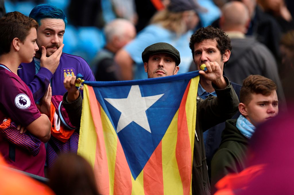 A fan holds up the Catalan pro-independence 'Estelada' flag before kick off of the English Premier League football match between Manchester City and Stoke City at the Etihad Stadium in Manchester, north west England, on October 14, 2017. (AFP / Oli SCARFF