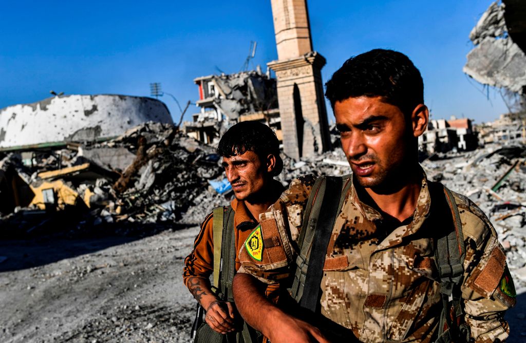 Members of the Syrian Democratic Forces (SDF), backed by US special forces, check the area near Raqa's stadium as they clear the last positions on the frontline on October 16, 2017 in the Islamic State (IS) group crumbling stronghold. AFP / BULENT KILIC
