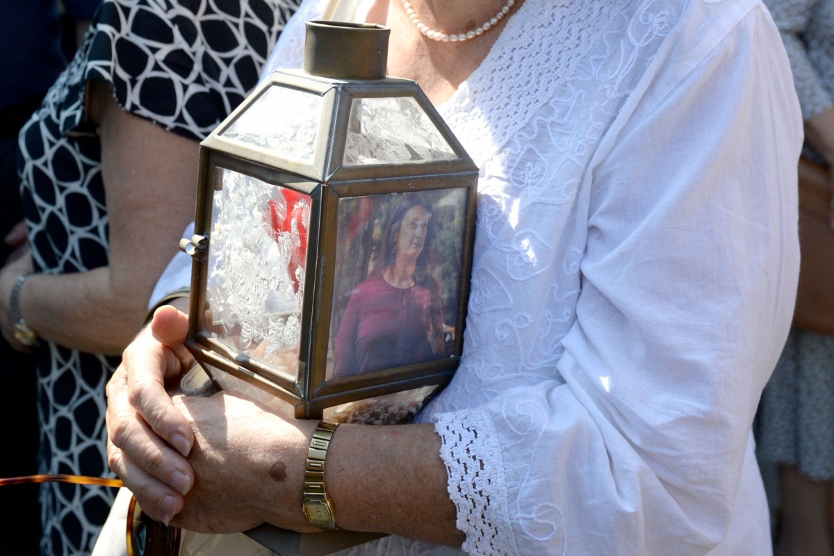 A woman holds a lantern with a picture of murdered journalist Daphne Caruana Galizia outside the law court in Valletta, Malta, on October 17, 2017 during a protest demanding for justice, a day after Maltese journalist Daphne Caruana Galizia was killed by 