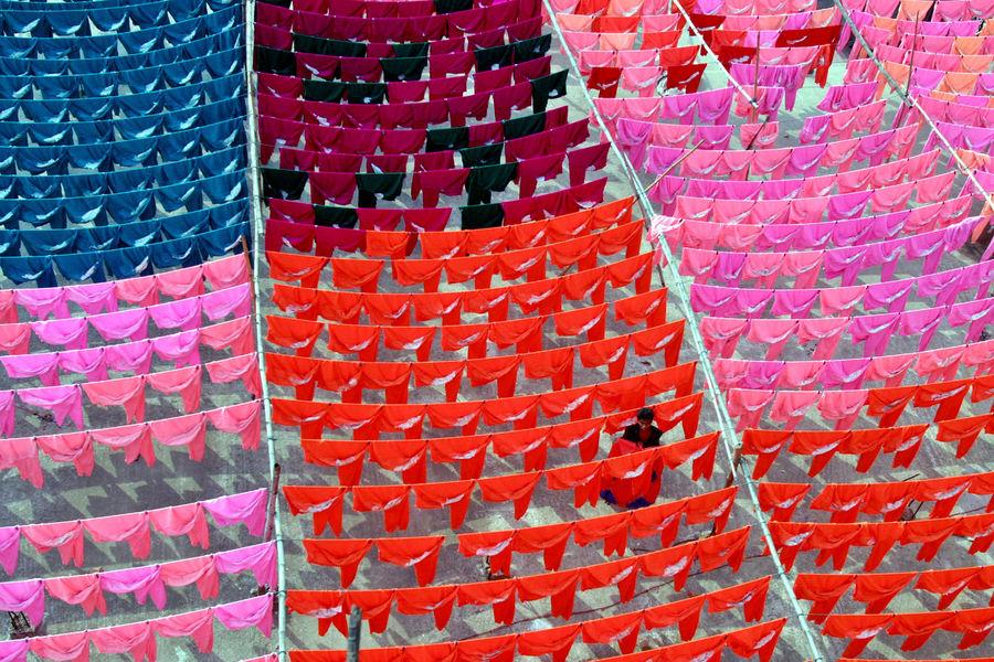 A worker hangs clothes to dry on the roof of a garment factory in Dhaka in this June 15, 2005 file photo.  Reuters / Rafiqur Rahman