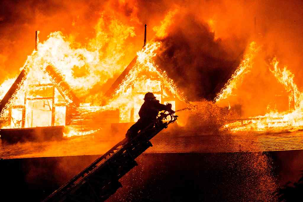 A firefighter extinguishes a fire at Kandawgyi Palace hotel in Yangon early on October 19, 2017. AFP / YE AUNG THU