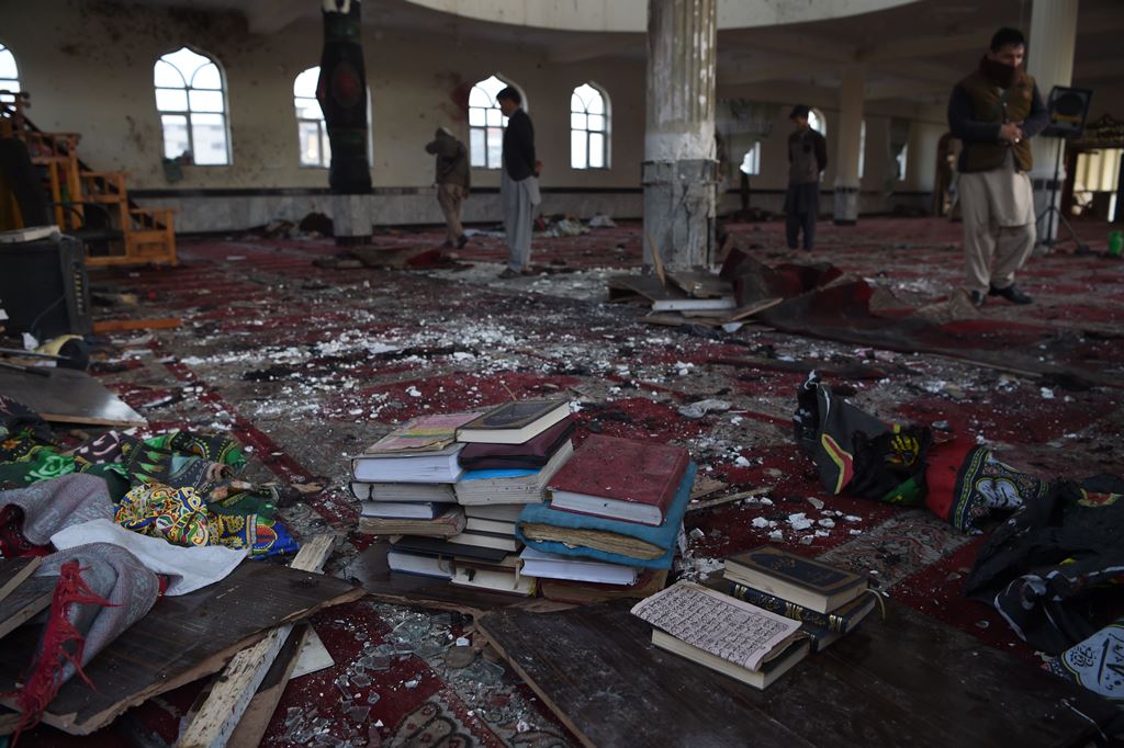 Afghan residents look inside the Imam Zaman Shiite mosque which was a the site of a suicide attack during evening prayers, in Kabul on October 21, 2017. AFP / WAKIL KOHSAR
