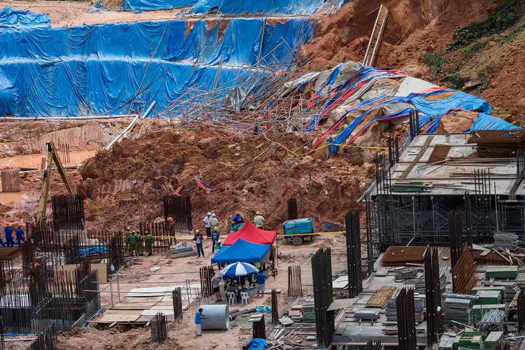 Rescue workers search for victims of a landslide at a construction site in Tanjung Bungah on the north of Penang on October 21, 2017./ AFP / STR