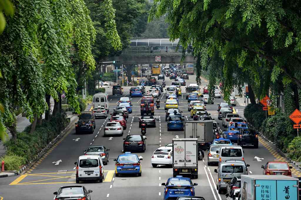 Motorists enter the financial district area in Singapore on October 24, 2017. Singapore, one of the most expensive places in the world to buy a vehicle, has announced it will freeze the number of private cars on its roads from next year but vowed to expan