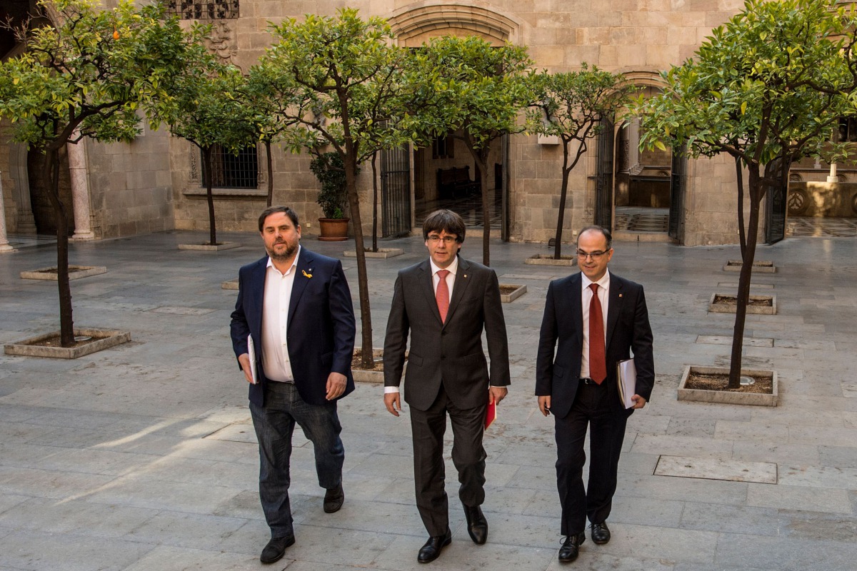 Catalan regional government president Carles Puigdemont (C) arrives with Catalan regional vice president and chief of economy and finance Oriol Junqueras (L) and Catalan government spokesperson Jordi Turull to attend a regional goverment meeting at the Ge