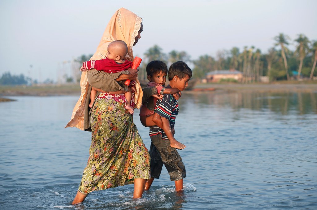 A Rohingya refugee family walks through water after crossing the Bangladesh-Myanmar border, at a port in Teknaf, Bangladesh October 25, 2017. REUTERS/Adnan Abidi
