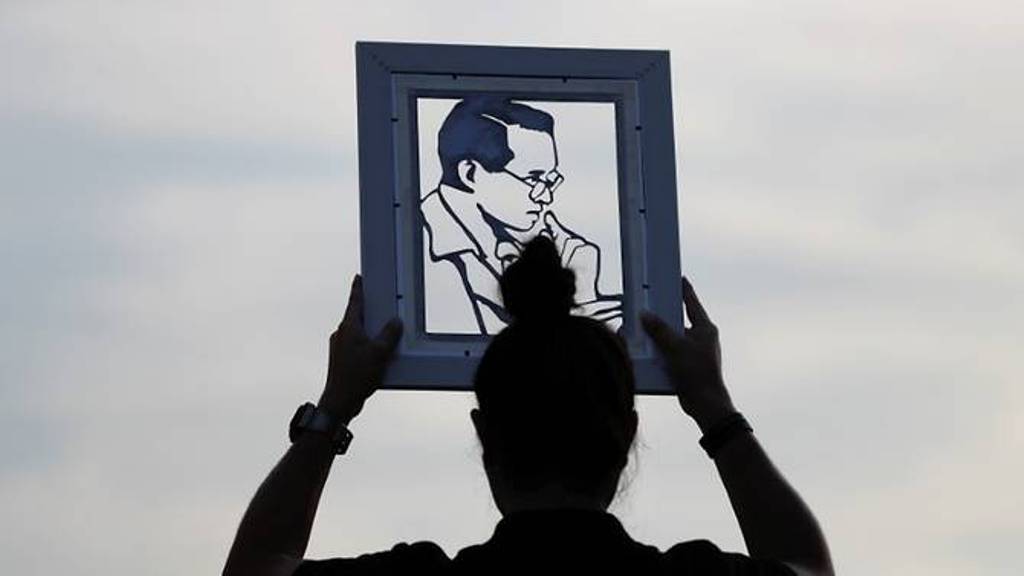 A woman holds the portrait of Thailand's late King Bhumibol Adulyadej as mourners wait for tomorrow's Royal Cremation ceremony near the Grand Palace in Bangkok. (Photo: REUTERS/Damir Sagolj).