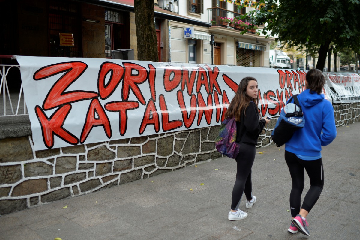 People walk past signs reading, 