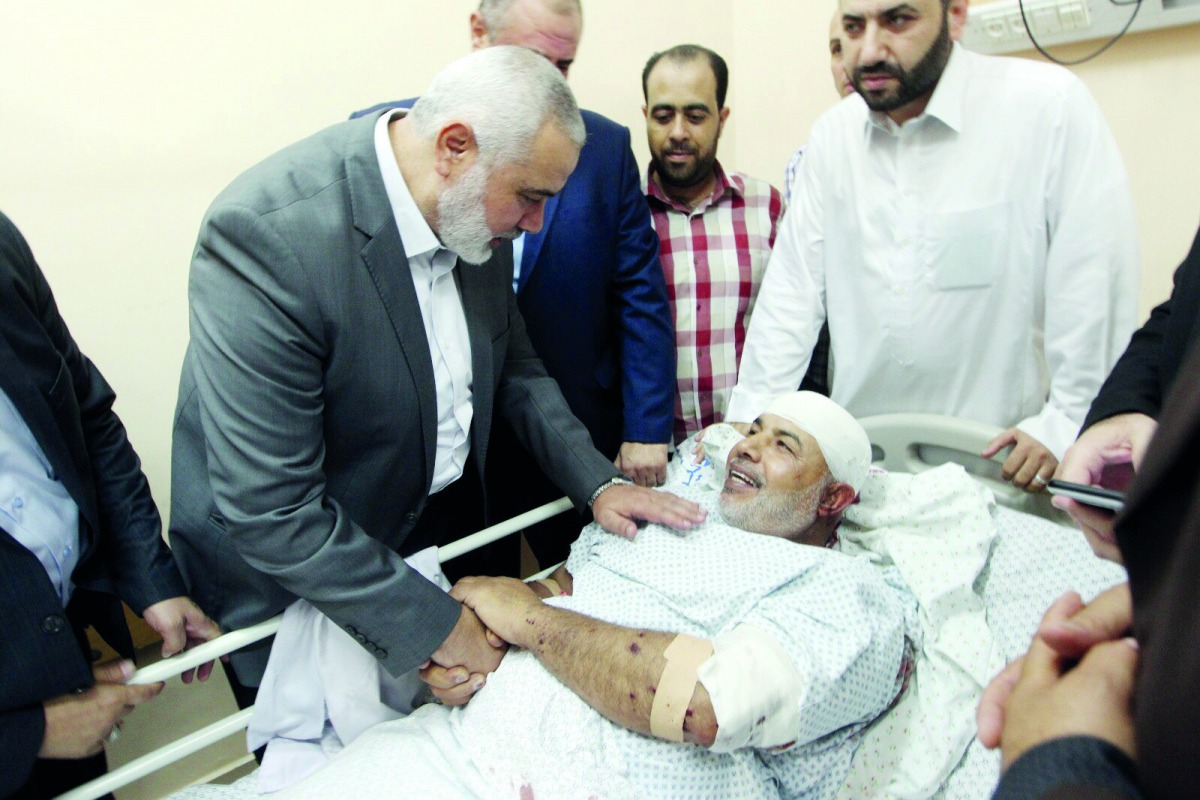 Hamas chief Ismail Haniyah visits injured Tawfeeq Abu Naeem at Al Shifa hospital in Gaza City, yesterday.
