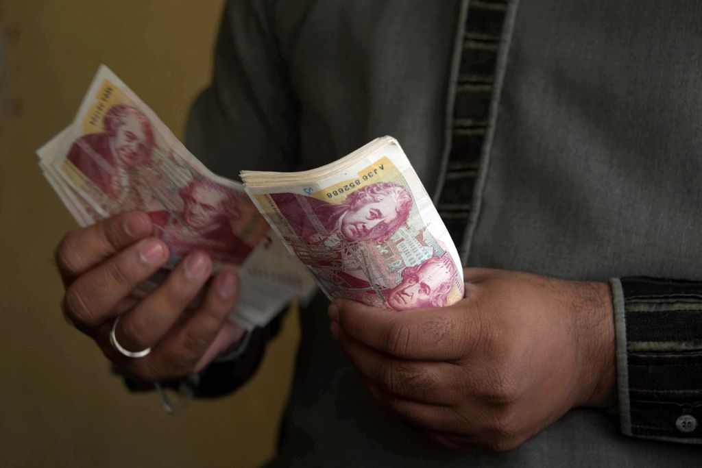 A file photo of  a Pakistani Kashmiri foreign currency dealer counting British pound notes at a remittance shop in the Pakistani Kashmir city of Mirpur, which is known as 