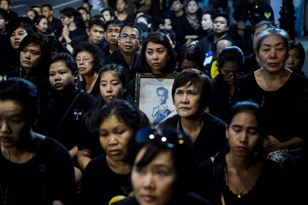 A mourner pray for the late Thai King Bhumibol Adulyadej during the procession transferring the relics and his ashes from the Grand Palace to a local temple in Bangkok on October 29, 2017. AFP / YE AUNG THU
