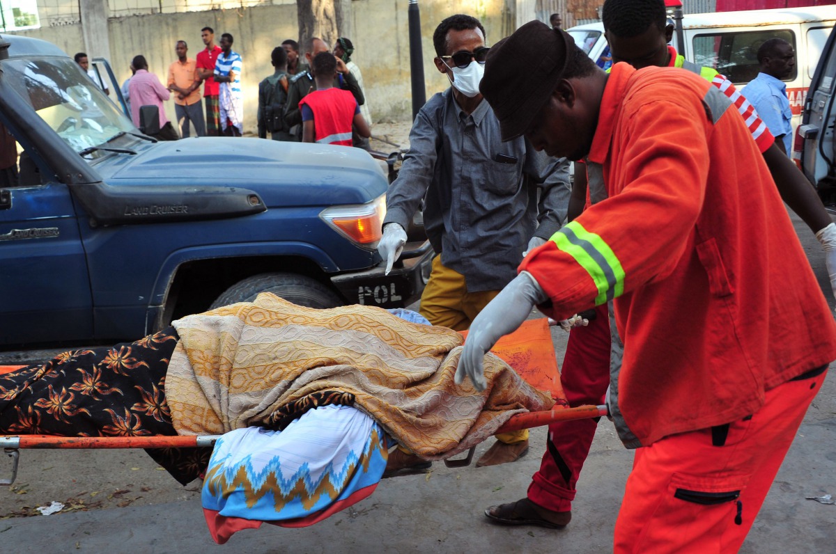 Somalis rescue workers carry the body of a victim at the scene of a blast on October 29, 2017, a day after two car bombs exploded in Mogadishu. AFP / Mohamed Abdiwahab
