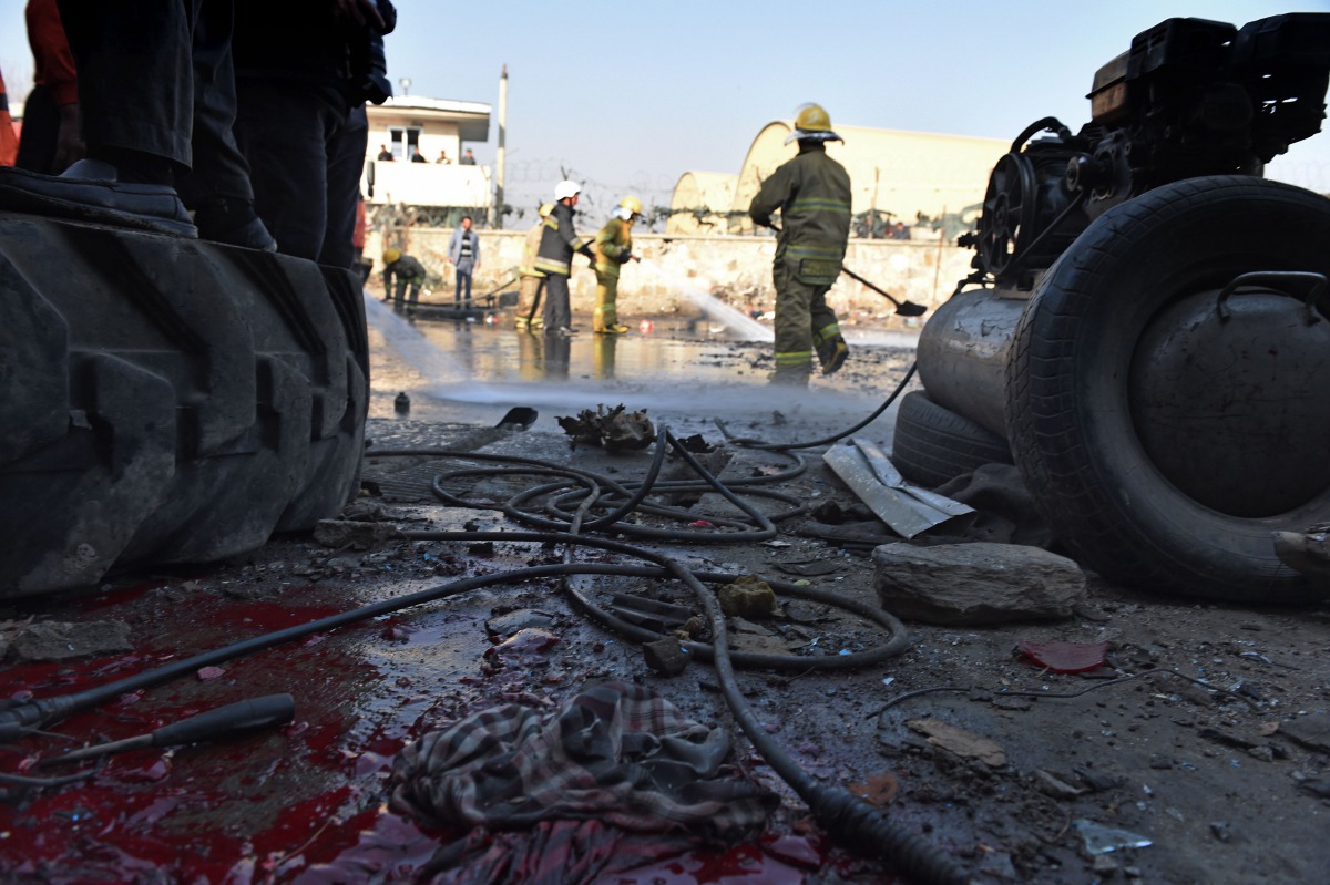 This file photo taken on December 27, 2015 shows Afghan firefighters washing a road at the site of a suicide car bomb perpetrated by a Taliban bomber near the international airport in Kabul. AFP / Shah Marai
