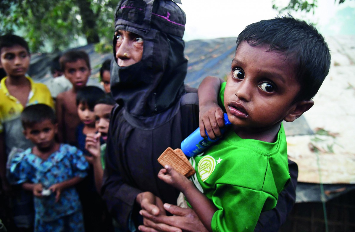 Rohingya Muslim refugee Fahima Bibi, 56, carries her grandson Mohammad Jabed, 2, as she walks back to their tent at Kutupalong refugee camp in the Bangladehsi distrcit of Ukhia on November 3, 2017. AFP / Dibyangshu Sarkar