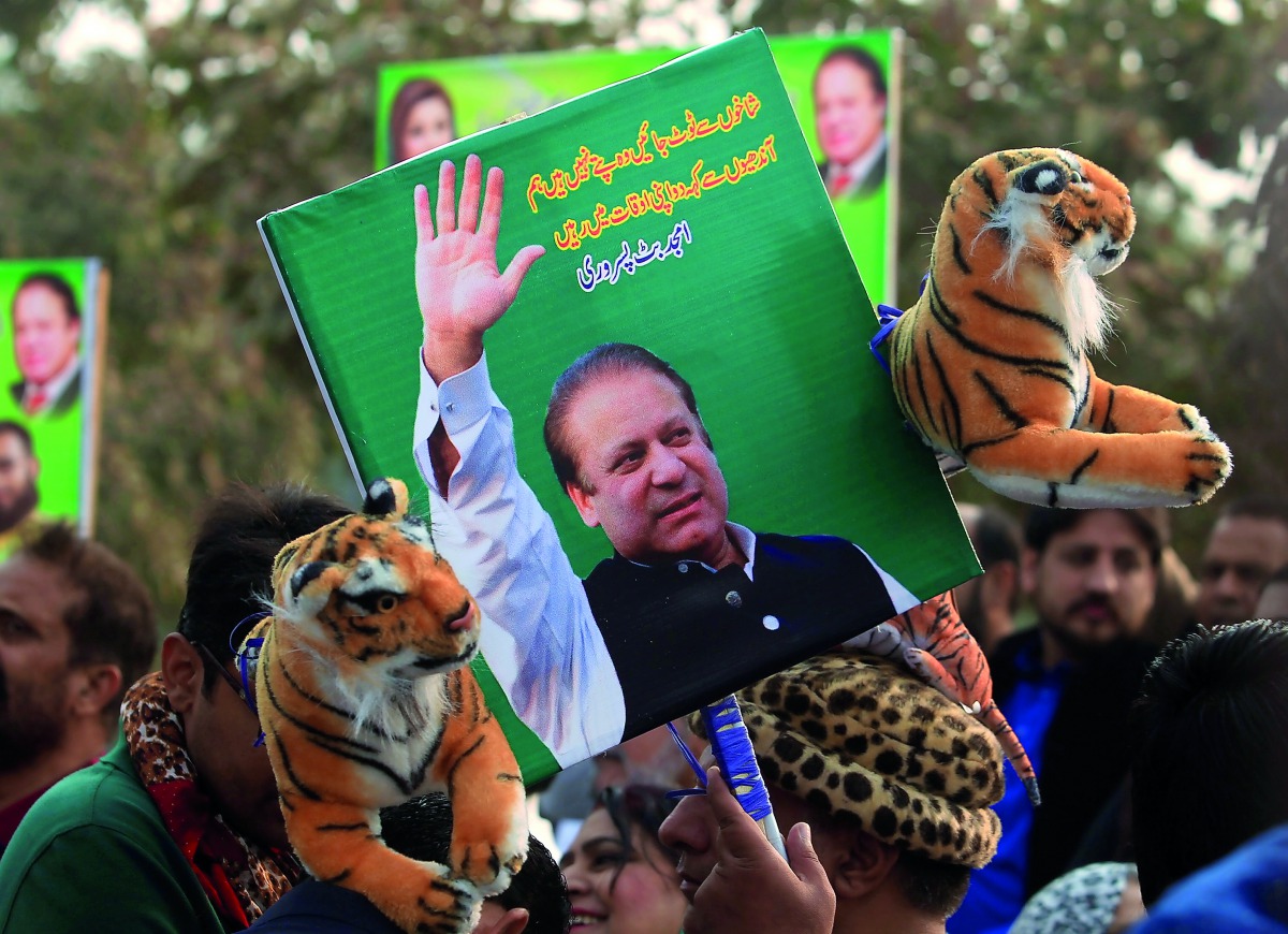 A supporter of the ruling Pakistan Muslim League (Nawaz) (PML-N) holds a picture of Nawaz Sharif outside the accountability court where he appeared to face corruption charges filed against him, in Islamabad, Pakistan November 3, 2017. Reuters/Faisal Mahmo
