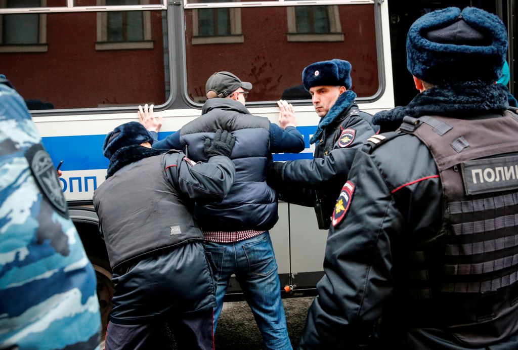 Russian police search an opposition activist during a protest rally in central Moscow on November 5, 2017.   AFP / Maxim ZMEYEV
