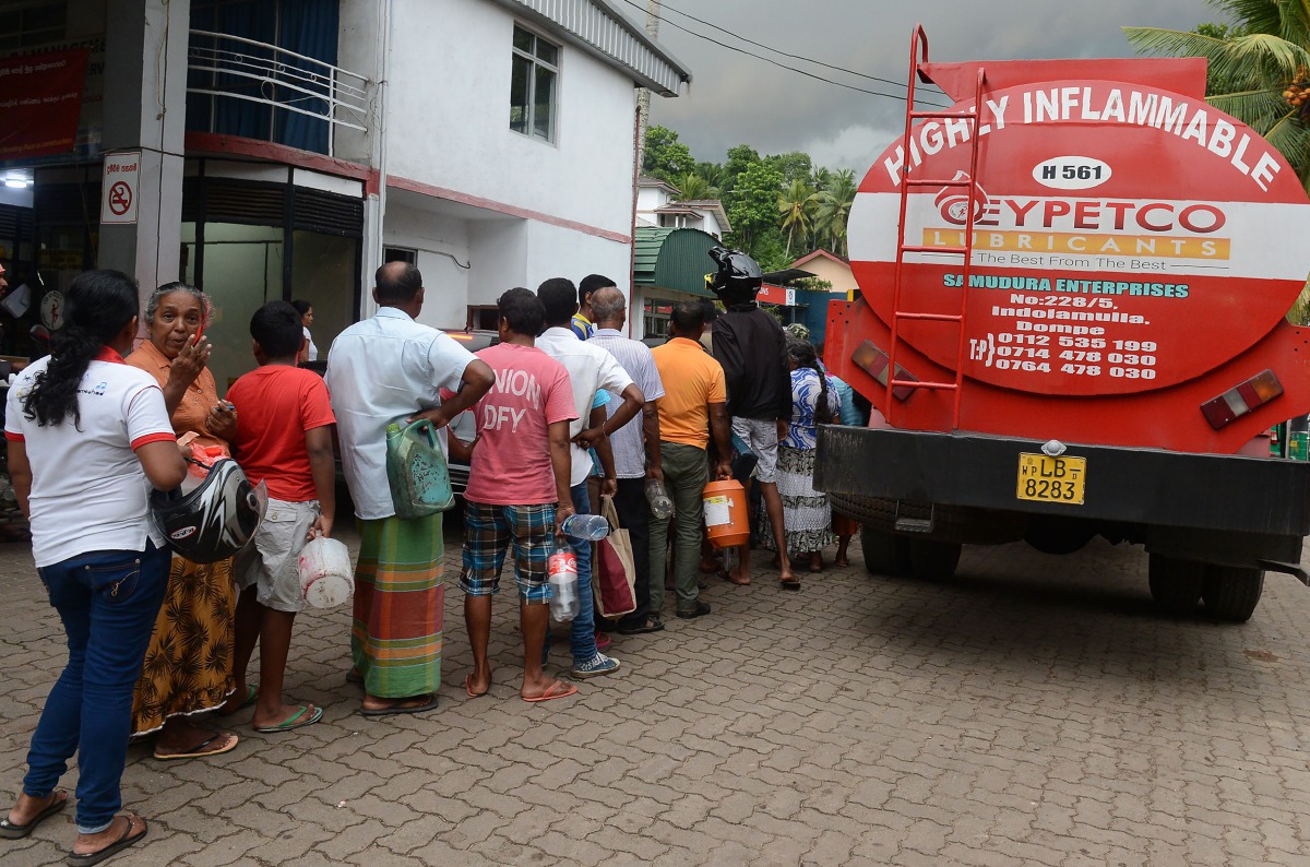 Sri Lankan commuters queue to buy petrol in Colombo on November 6, 2017. AFP