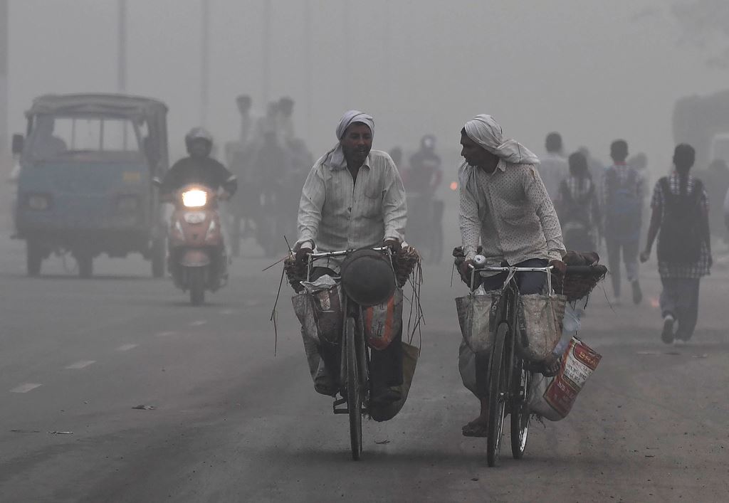 Indian commuters drive amid heavy smog in New Delhi on November 7, 2017. AFP / PRAKASH SINGH
