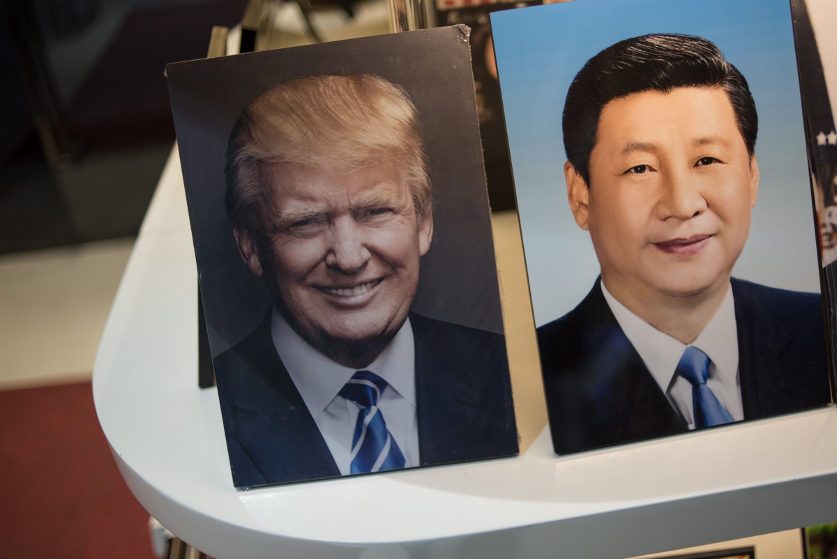 Framed photographs of Chinese President Xi Jinping (R) and US President Donald Trump are seen on display in a photo shop in Beijing on November 6, 2017. Donald Trump arrives in China on November 8, which is the third stop of his tour in Asia. / AFP / FRED