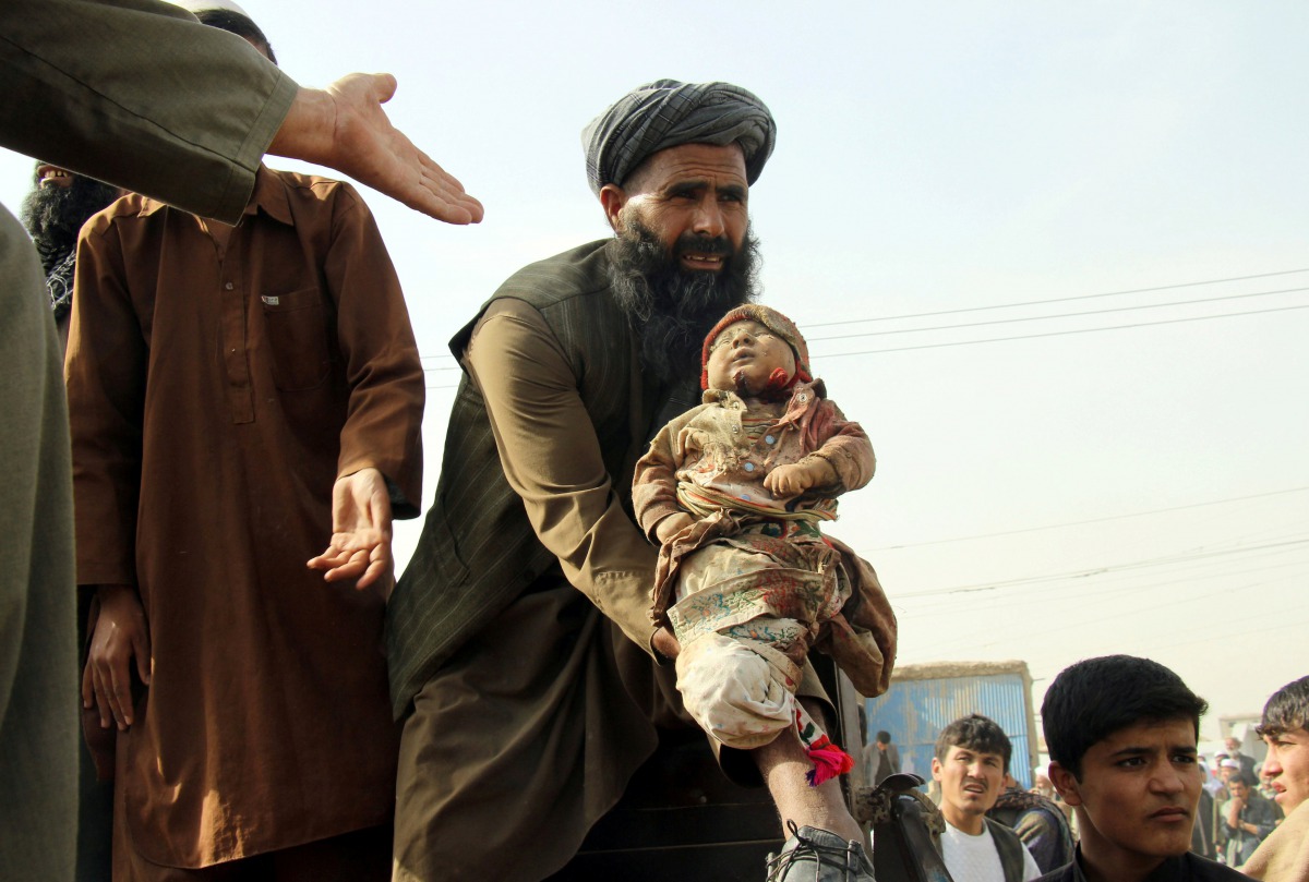 FILE PHOTO: An Afghan man holds up the dead body of a child  killed by an air strike called in to protect Afghan and US forces during a raid on suspected Taliban militants in Kunduz, November 3, 2016 (Reuters / Nasir Wakif) 