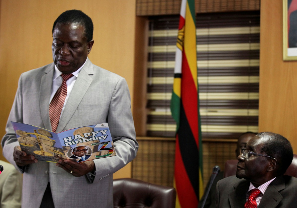 FILE PHOTO: Zimbabwe's President Robert Mugabe looks on as his deputy Emmerson Mnangagwa reads a card during Mugabe's 93rd birthday celebrations in Harare, Zimbabwe, February 21, 2017. Reuters/Philimon Bulawayo