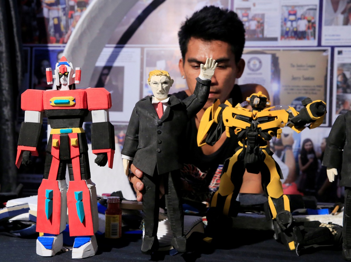 Elmer Padilla, 30, who is famous for creating action figures out of discarded slippers, makes a figure of U.S. President Donald Trump (C) at his workshop in metro Manila, Philippines, November 8, 2017. Reuters/Romeo Ranoco