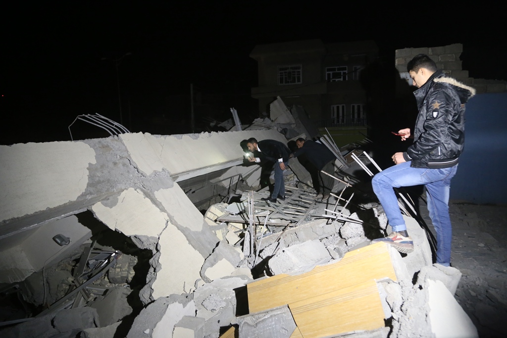Iraqis search for the trapped citizens over the collapsed buildings after a 7.3 magnitude earthquake hit northern Iraq in Derbendihan district of Sulaymaniyah, Iraq on November 12, 2017. (Feriq Fereç - Anadolu Agency)
