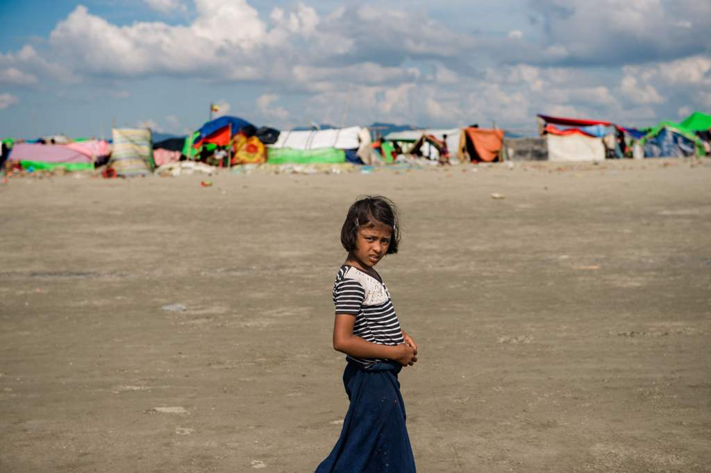 In this photograph taken on November 12, 2017, a girl stands on the sandy banks of the natural boundary between Myanmar and Bangladesh near a makeshift camp in Rakhine state in Myanmar.  AFP / Phyo Hein KYAW