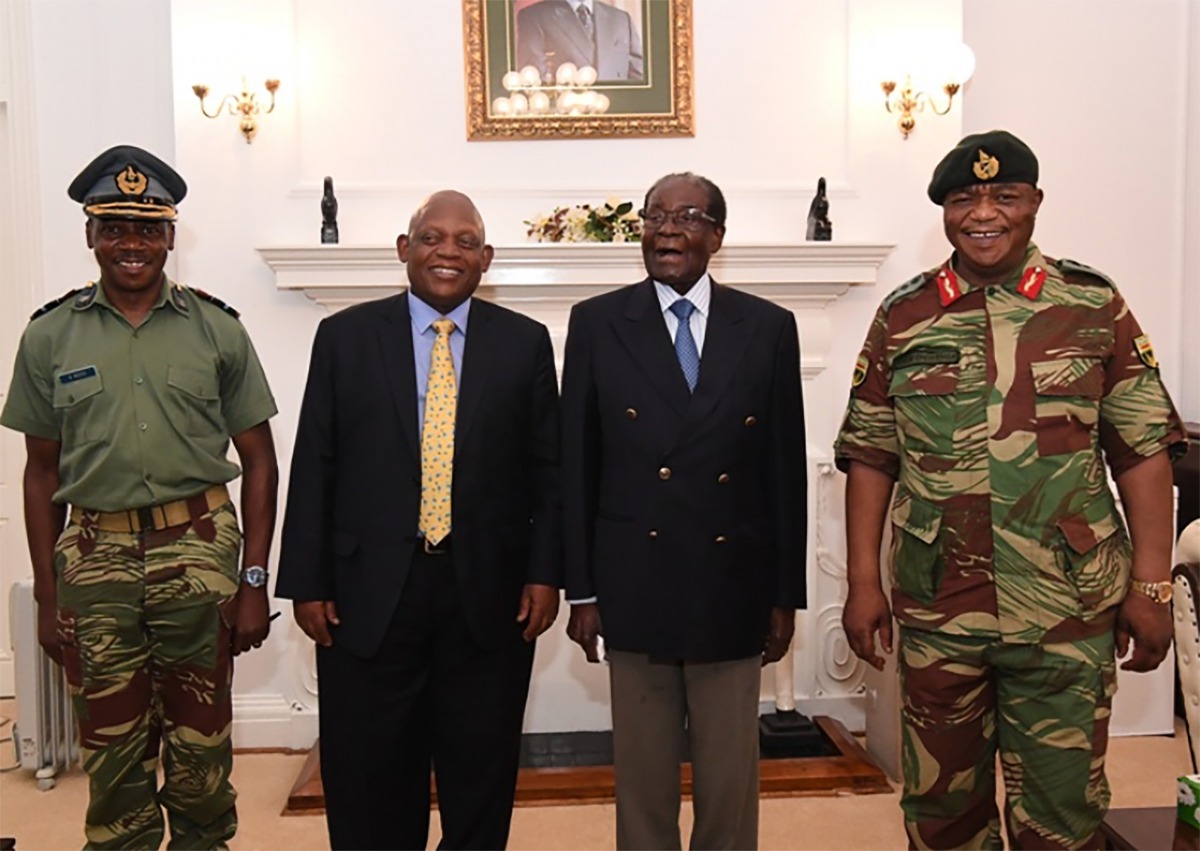 This screengrab from Zimbabwe Broadcasting Corporation (ZBC) taken on November 16, 2017, shows Zimbabwe President Robert Mugabe (2R) as he poses alongside Zimbabwe Defence Forces Commander General Constantino Chiwenga (R) and South African envoys at State