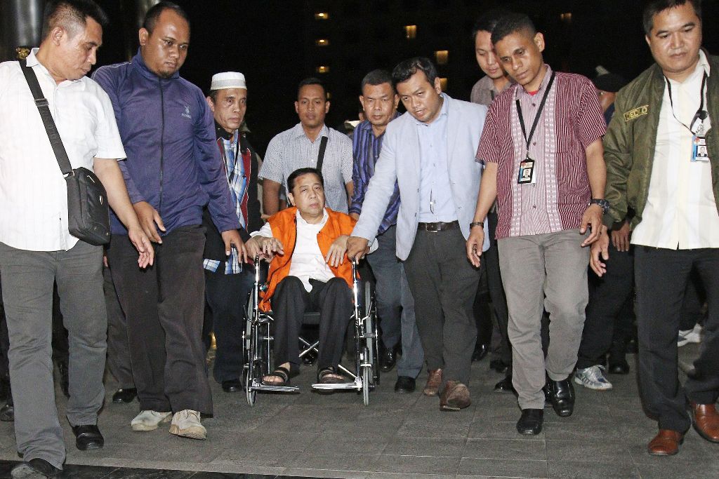 This picture taken on November 19, 2017 shows Parliament speaker Setya Novanto (in orange) being escorted by officials from the Corruption Eradication Commission (KPK) in Jakarta. / AFP.
