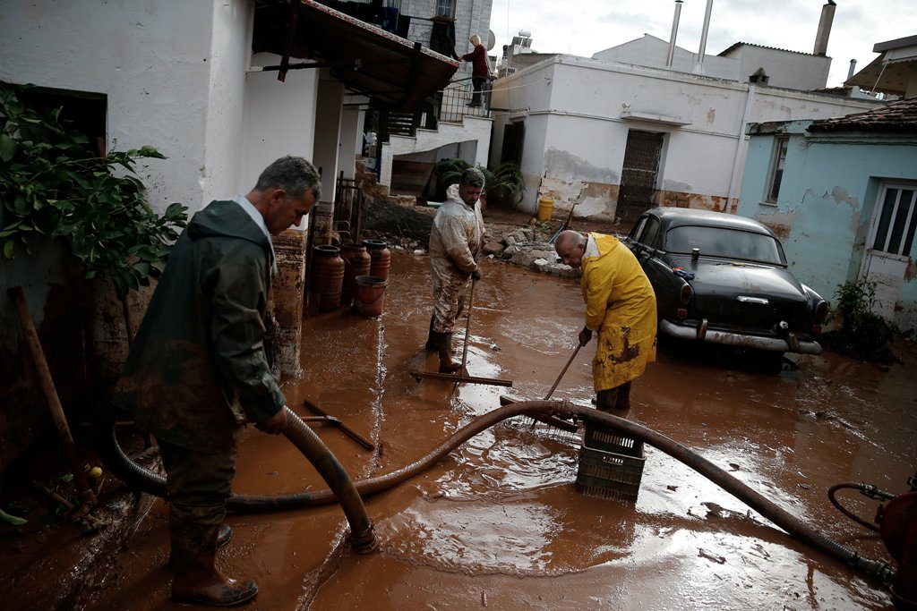 Locals remove mud from the entrance of their house, following flash floods which hit the town of Mandra, Greece, November 18, 2017. REUTERS/Costas Baltas.