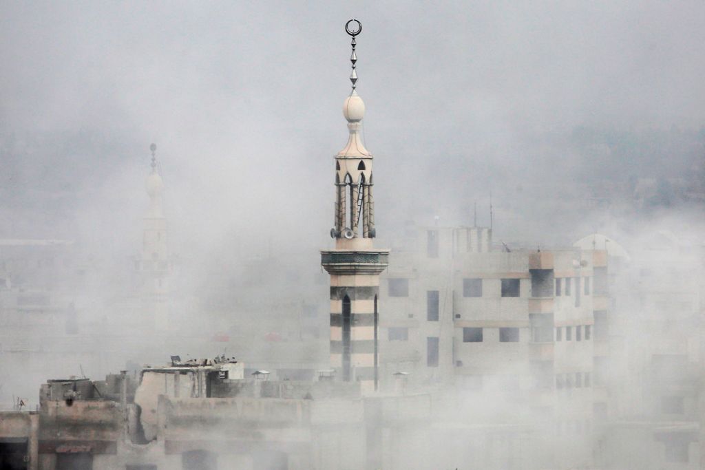 Smoke covers buildings following an air strike on the rebel-held besieged town of Arbin, in the Eastern Ghouta region on the outskirts of Damascus, on November 18, 2017. / AFP / Amer ALMOHIBANY