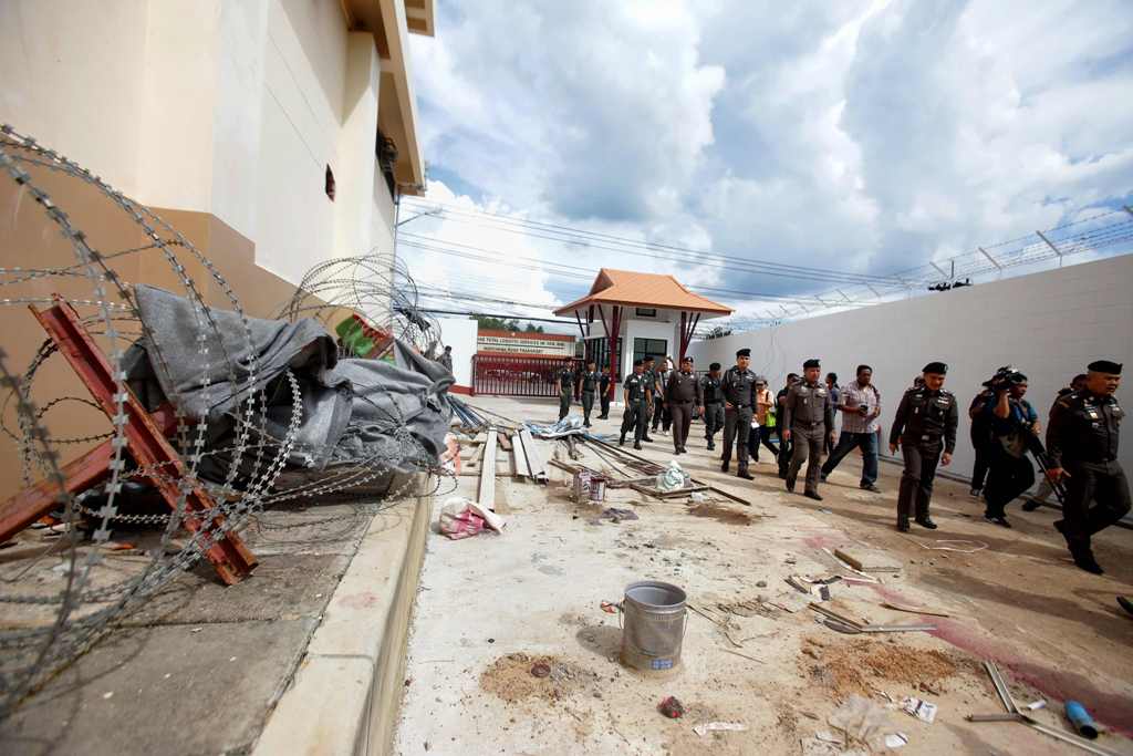 A photo of Police inspecting the exterior of an immigration detention centre, from where 20 ethnic Uighurs escaped on Monday morning, in Sadao district in the southern Thai province of Songkhla on November 21, 2017. / AFP / TUWAEDANIYA MERINGING

