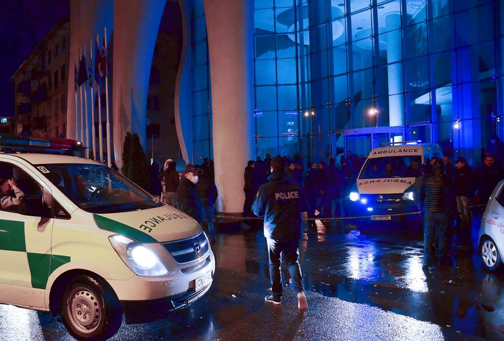 Georgian police investigators and ambulance cars are seen in front of the Leogrand hotel in Georgia's Black Sea resort city of Batumi on November 24, 2017. At least 12 people died and a dozen were injured on November as a fire ripped through an upmarket h