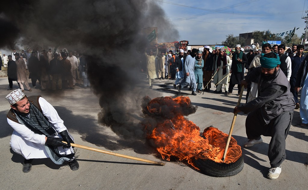 Pakistani protesters from the Tehreek-i-Labaik Yah Rasool Allah Pakistan (TLYRAP) burn tyres during a protest in Peshawr on November 25, 2017. (AFP / ABDUL MAJEED)