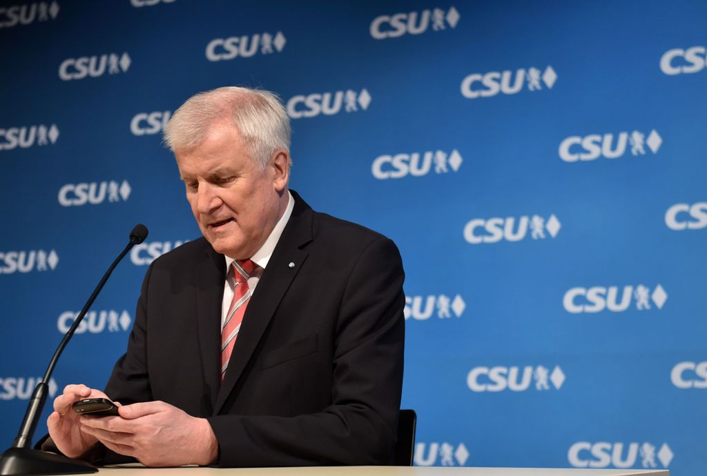 Bavaria's State Premier and leader of the Christian Social Union (CSU) party, Horst Seehofer checks his mobile phone prior a press conference after the CSU meeting at the party headquarters in Munich, southern Germany, on November 23, 2017. / AFP / CHRIST