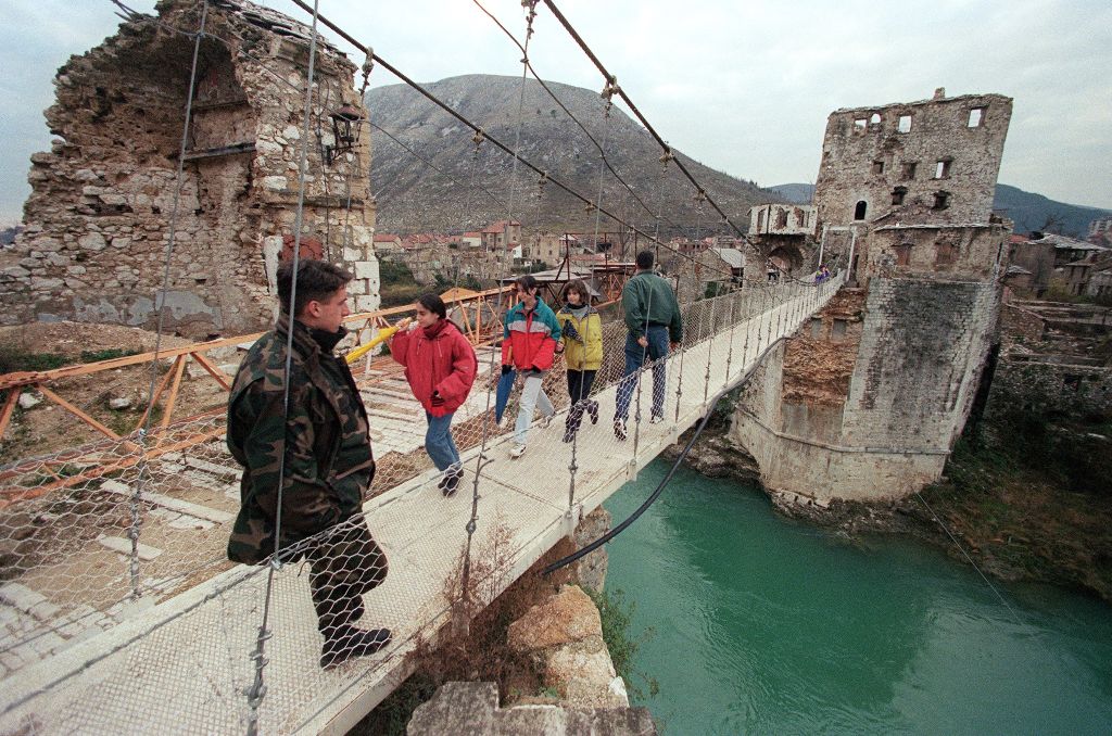 A file photo of Bosnian soldier standing on a hanging footbridge which replaced the old bridge of Mostar, southern Bosnia taken on December 17, 1995. / AFP / PASCAL GUYOT